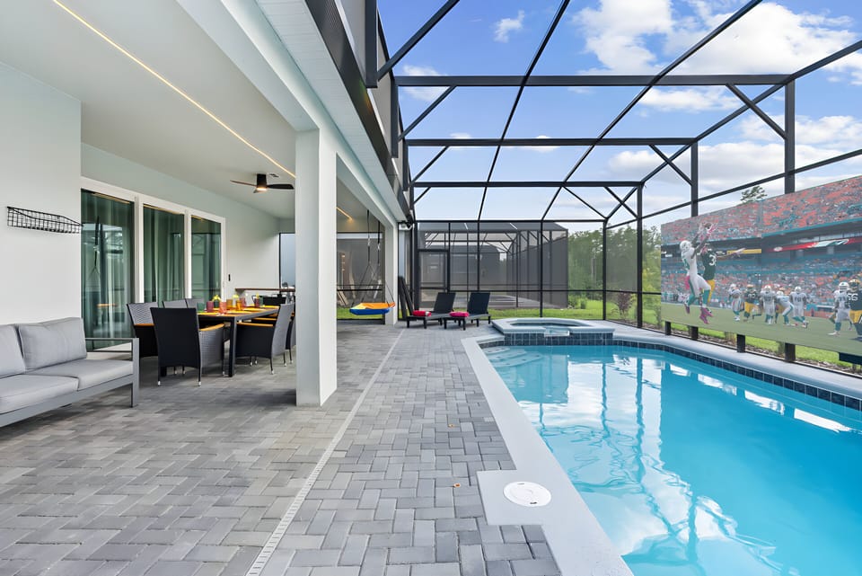 Step outside to a sleek patio where you can unwind by the sparkling pool, surrounded by modern pavers and a stylish enclosure. Enjoy cozy seating and a vibrant atmosphere, ideal for relaxing afternoons.