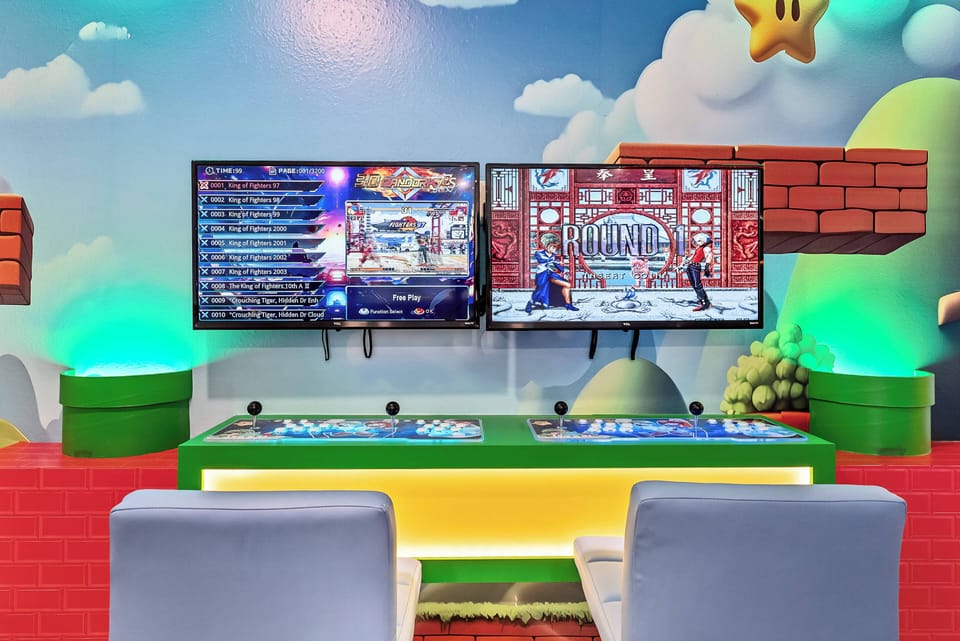 Enjoy a vibrant gaming area featuring two large screens and lively graphics. The colorful decor and sleek consoles create a fun atmosphere for family and friends, while comfy seating beckons you to relax and play for hours.