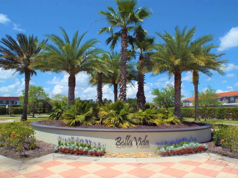 Step into an oasis where vibrant palm trees sway gently in the breeze, framing a beautifully landscaped entrance. The lush greenery and colorful blooms create a welcoming atmosphere that invites relaxation and enjoyment.