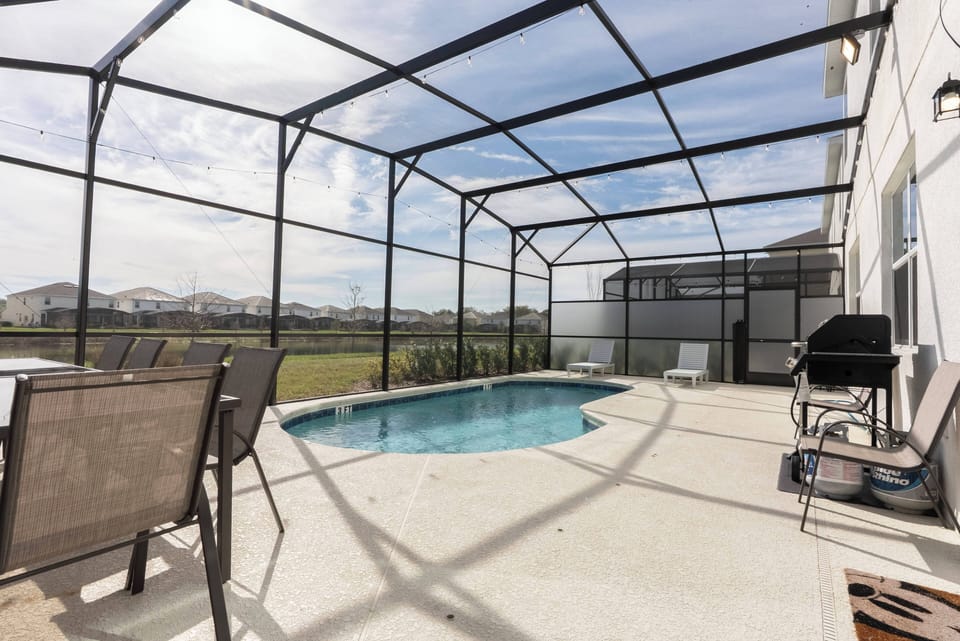 Step into your own private oasis featuring a sparkling pool surrounded by a spacious screened patio. The comfortable loungers invite you to unwind while you soak up the sun, all with a backdrop of lush greenery and open views.