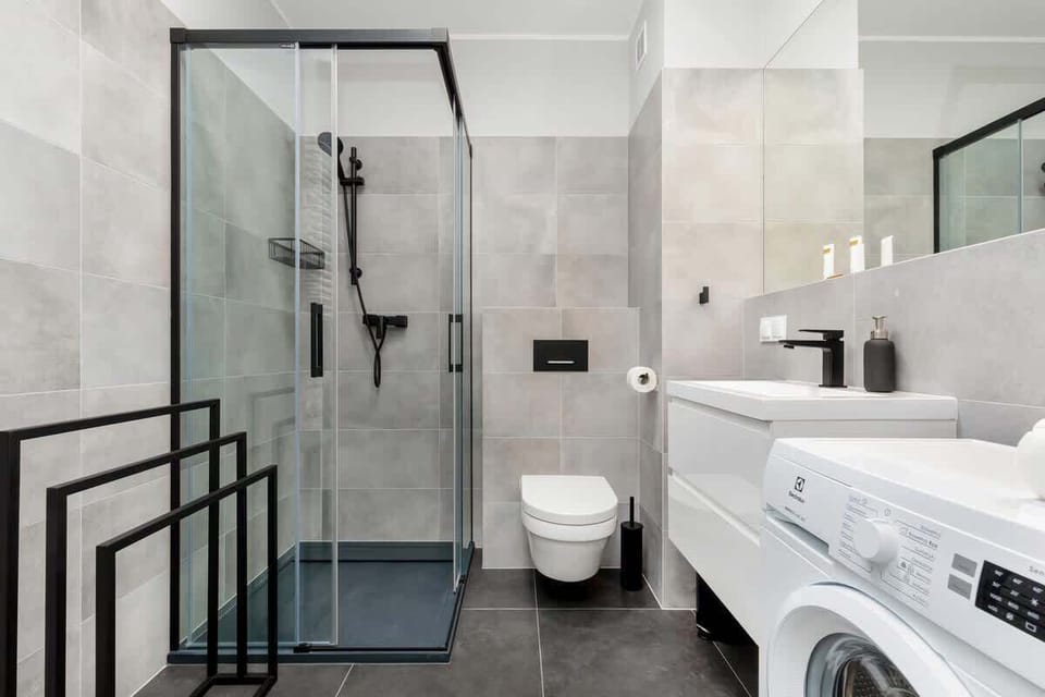 Bathroom with washing machine and towels. 