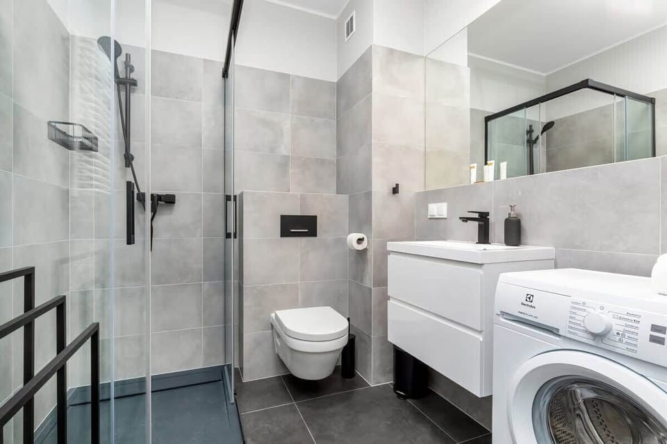 Bright bathroom with washing machine and shower cabin. 