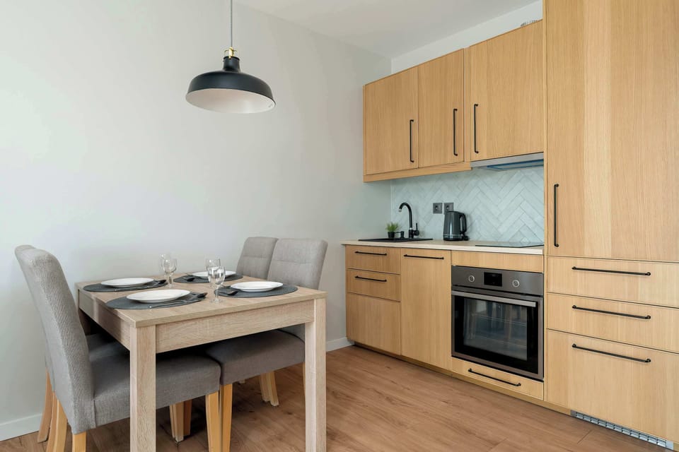 Wooden kitchen cabinetry paired with a stylish dining area for four creates a functional and elegant hub for everyday living.