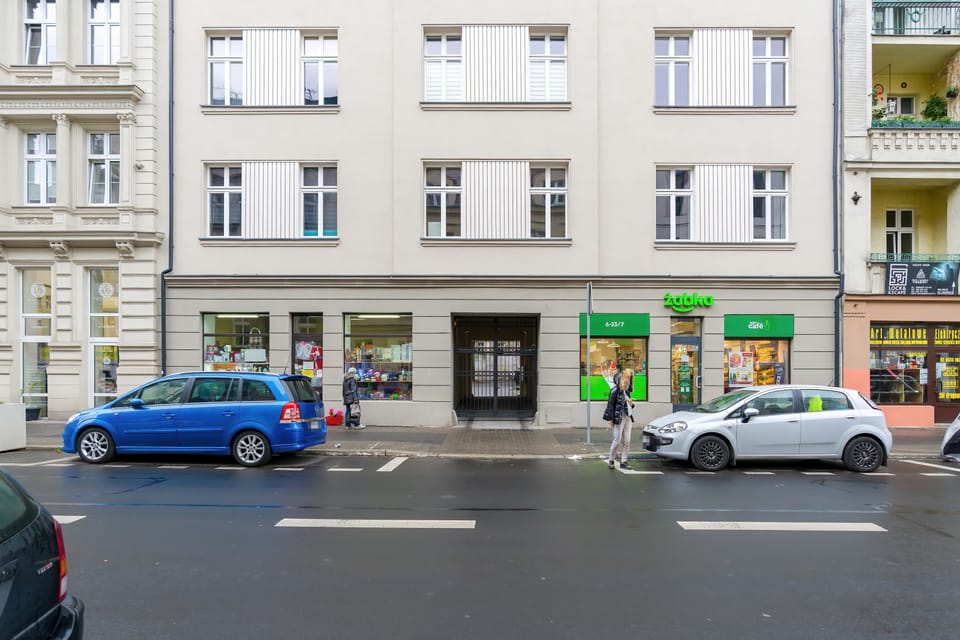 The exterior of the  building with cars parked along the street.
