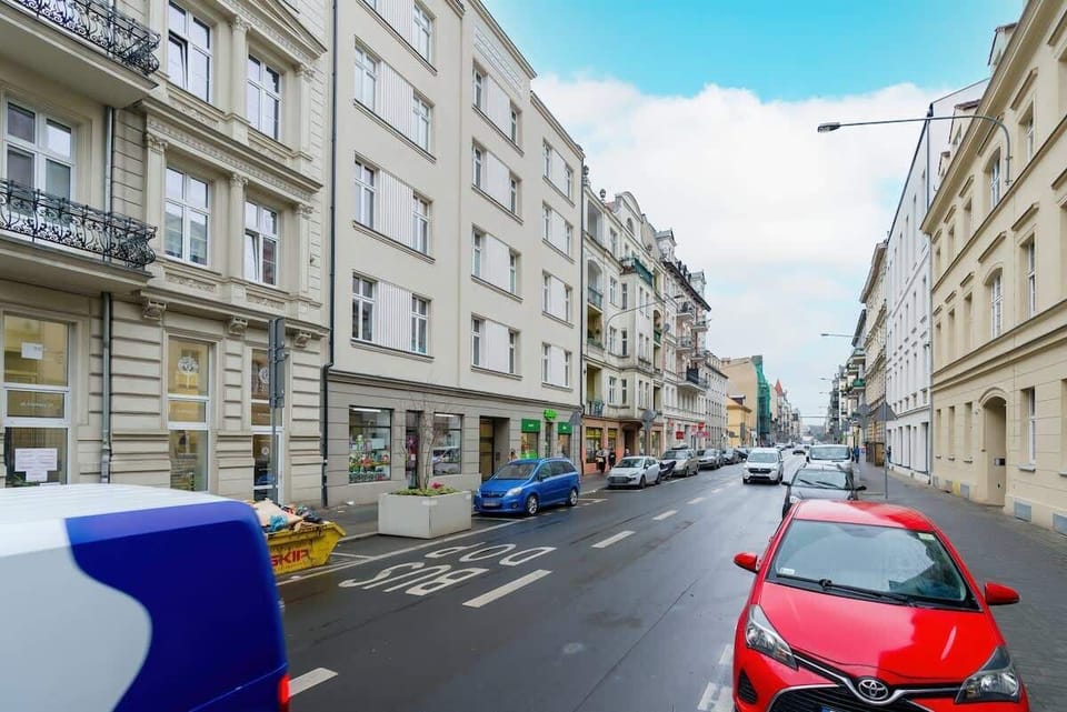 Another view of the street, showing the building exterior and nearby architecture.