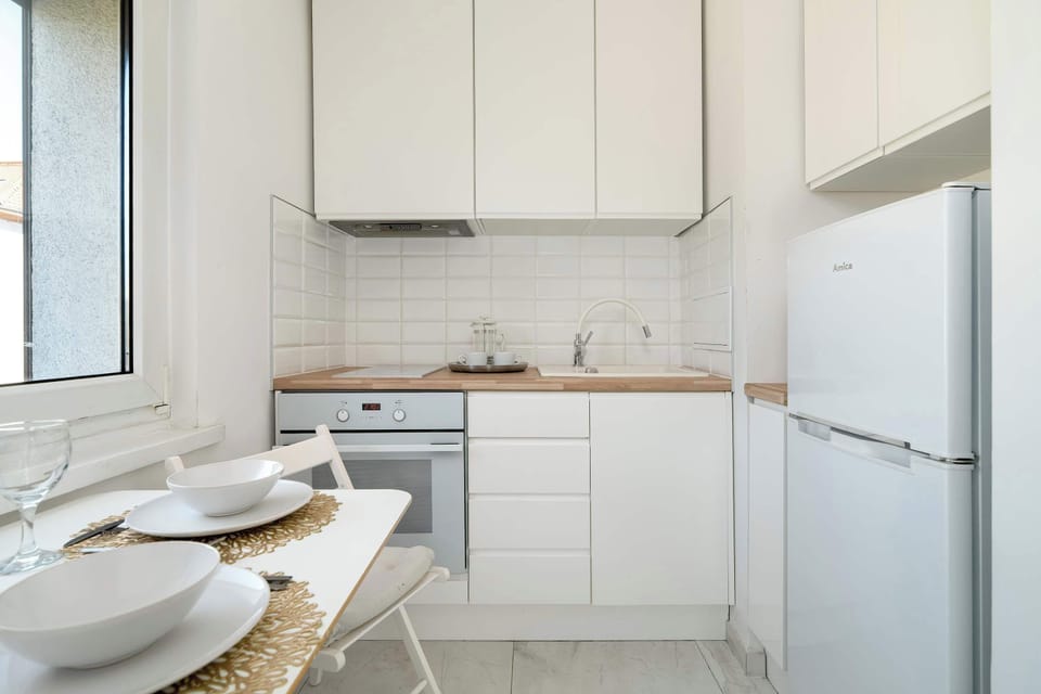 The functional kitchen with a large fridge and full dish set makes home cooking easy.