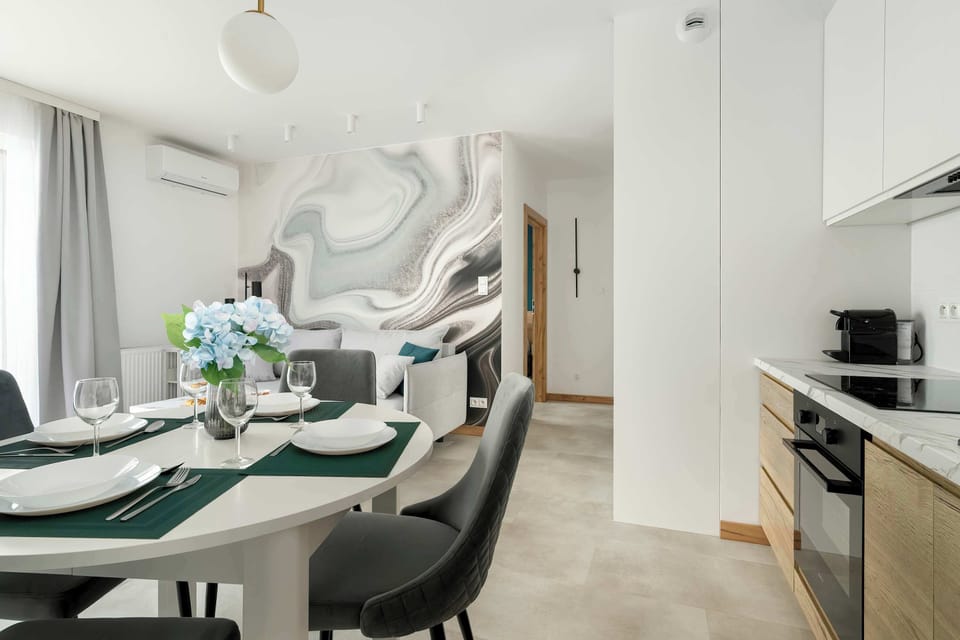 A kitchen with light-colored cabinets, a bright countertop, and a view into the dining area.