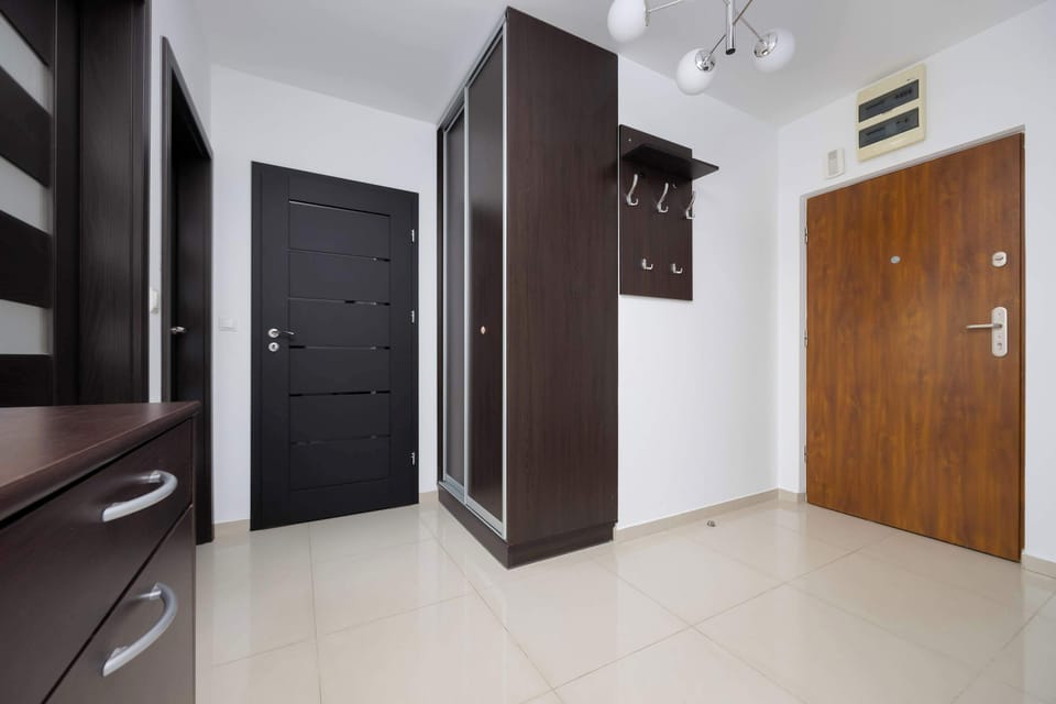 Hallway and entrance area with built-in cabinets and a secure front door.