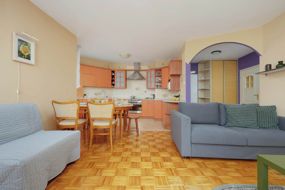 Living room with a two sofa beds (double and single), TV and kitchenette.