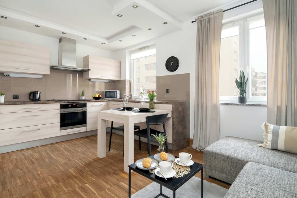 A spacious living room with an open layout connecting to the kitchen. The combination of neutral tones and elegant décor makes the space feel warm and stylish.