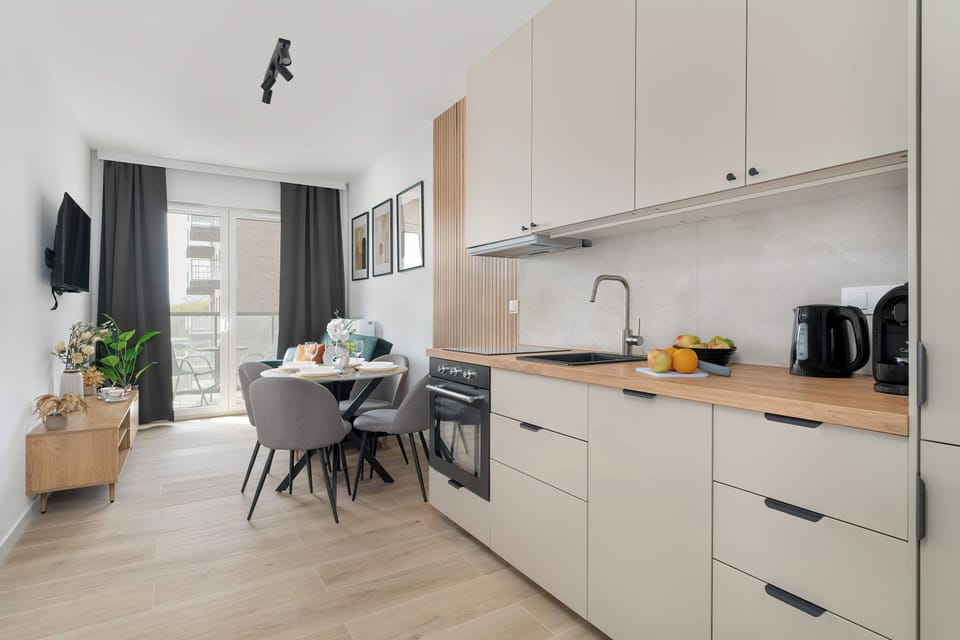 A kitchen and dining space with natural light, modern appliances, and a neutral color palette.