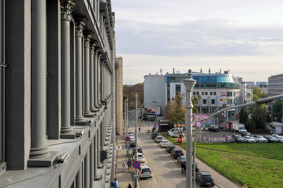 A panoramic outlook from the balcony, revealing a vibrant city scene with historic buildings.







