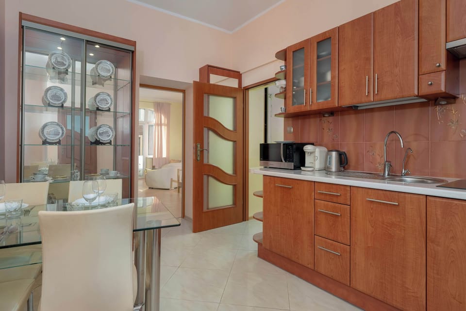 A combined kitchen and dining area with wooden cabinets, a dining table, and chairs.

