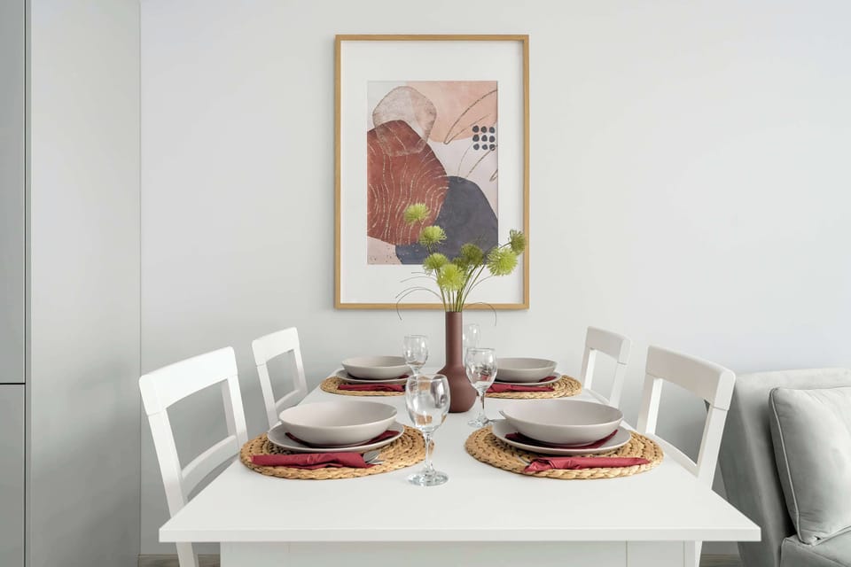Dining area dedicated for four people located next to the grey single sofa bed.