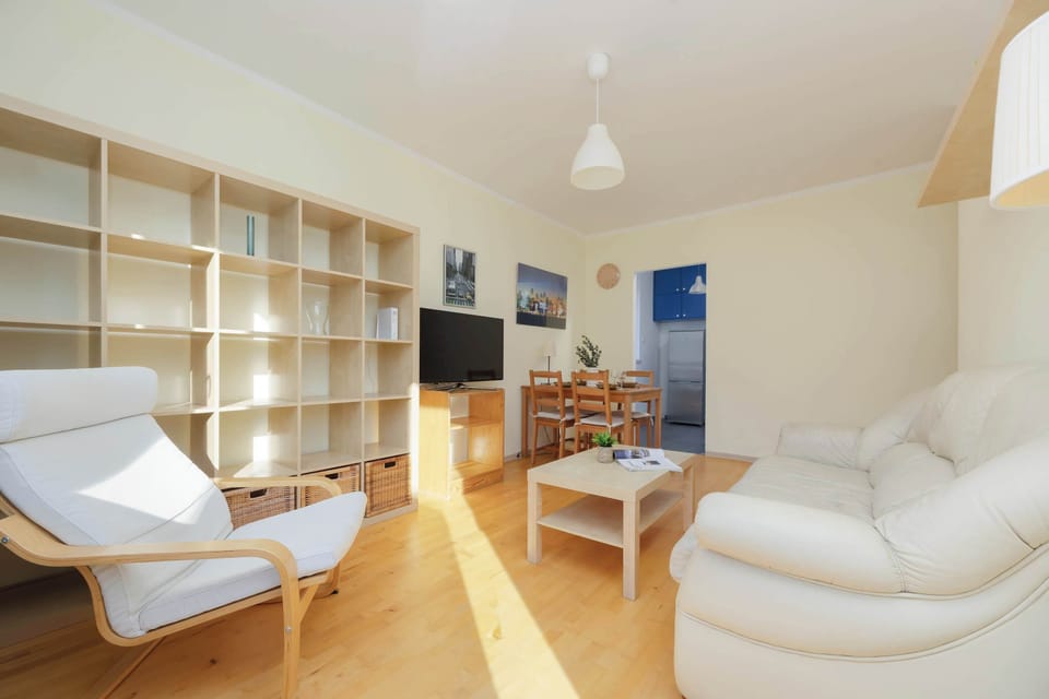 Cozy & bright living room with a sofa bed, TV, dining area and exit to balcony.