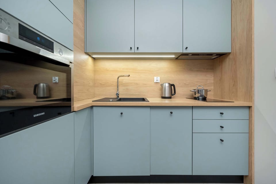 An alternate view of the kitchenette showing modern cabinetry, built-in stove, and integrated appliances.

