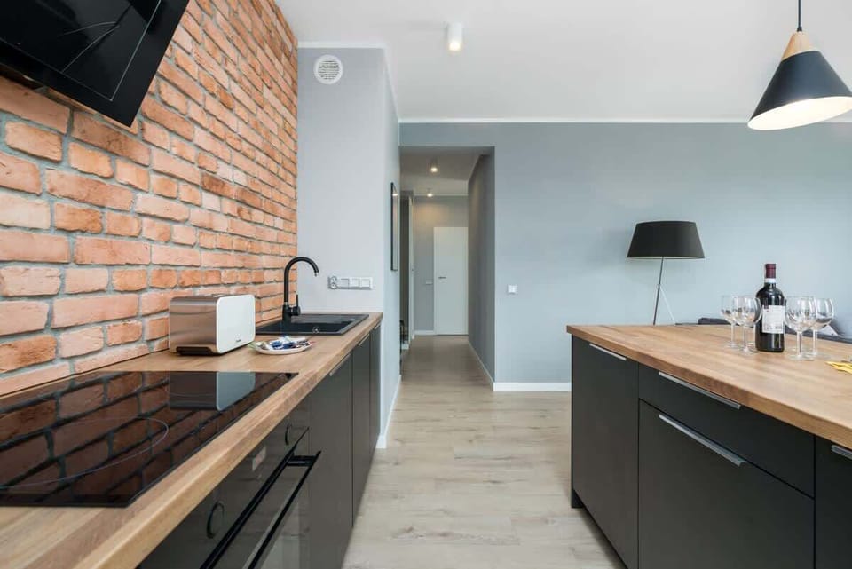 Another perspective of the kitchen, focusing on the induction cooktop and stylish wooden counter space.
