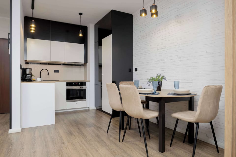The dining area connects seamlessly with the living room, featuring a table set for two and subtle decor that creates a welcoming atmosphere.