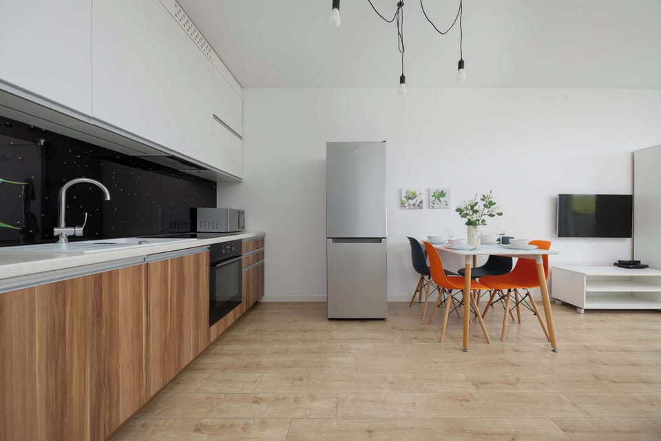 A black-and-white kitchen with wood finishes pairs perfectly with the adjoining dining area.
