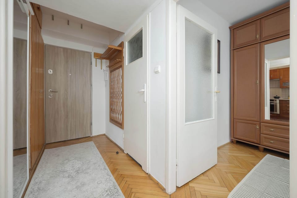 A spacious hallway with a mirrored wardrobe makes organization easy and gives a welcoming touch.