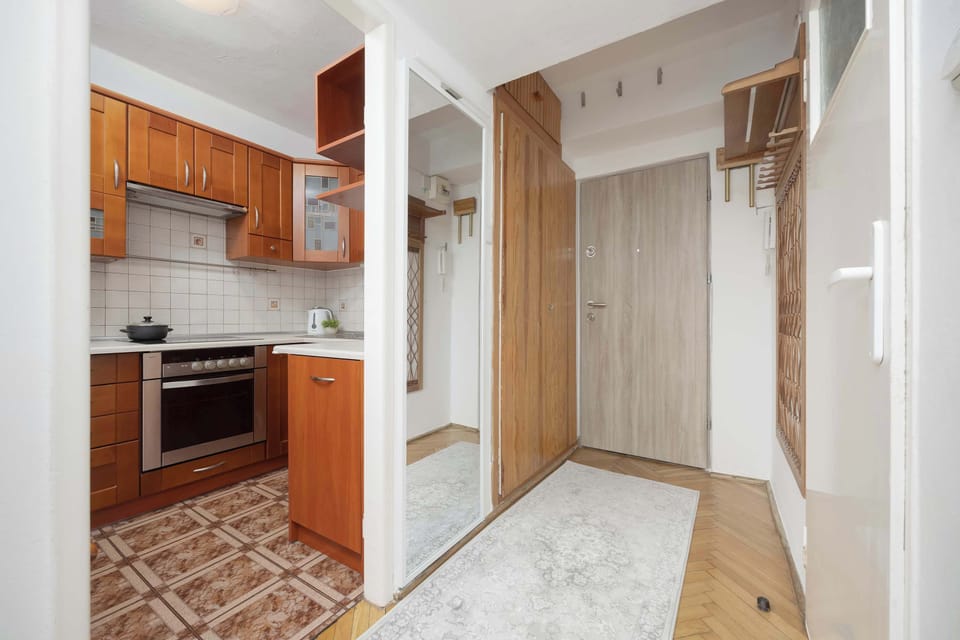 A practical hallway with cabinets and hooks offers convenient storage for coats and shoes.