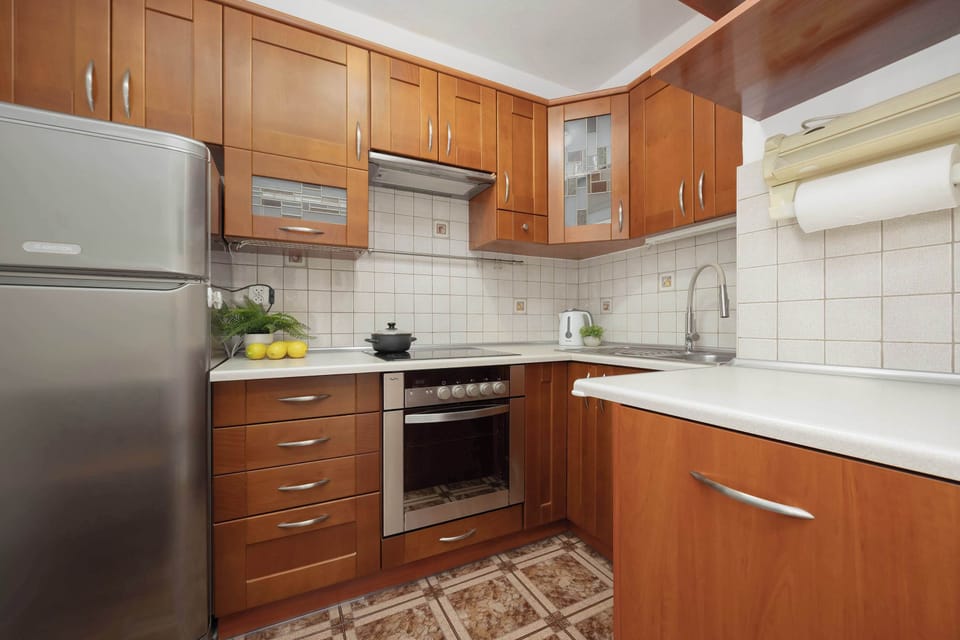 The wooden-finished kitchen with a large fridge is perfect for extended stays.
