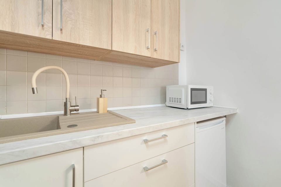 A closer look at the kitchen, highlighting the sink, countertop, and storage, perfectly blending functionality with minimalistic design.