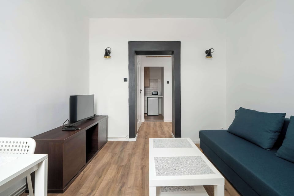 A bright living area with a comfortable sofa that provides a restful night's sleep and gives you the opportunity to relax and unwind in front of the TV which is opposite.