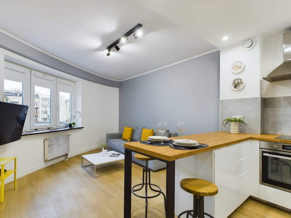 Modern dining area with a wooden table and high chairs.
