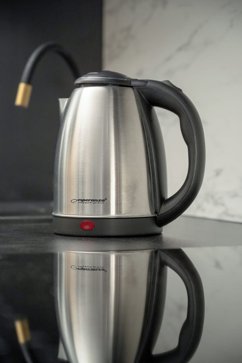 A stainless steel electric kettle sits on the kitchen countertop, ready for quick and convenient use, adding to the well-equipped kitchen setup.
