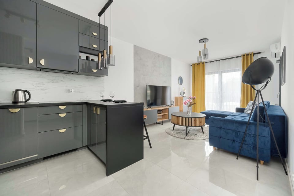 The modern kitchen with sleek gray cabinets, stainless steel appliances, and a functional island with a stool, creating a perfect cooking and dining space.