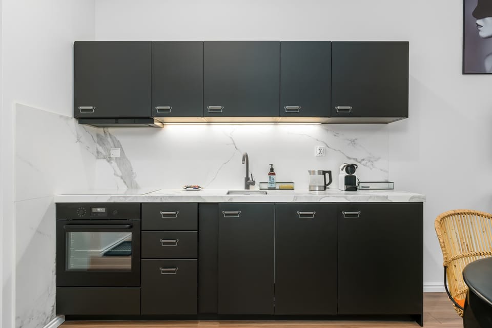 A focus on the kitchen area, highlighting the sink, stove, and black cabinetry.