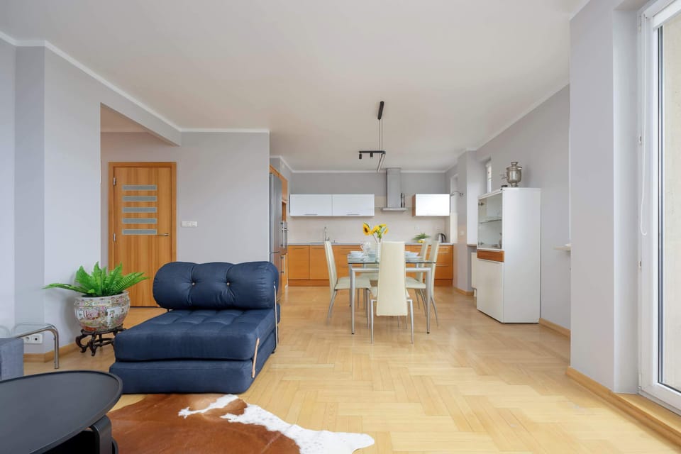 A lounge area with a blue sofa set and a flat-screen TV on a wooden cabinet.
