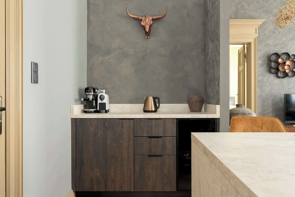 A darker-toned kitchen corner featuring a wooden cabinets, gray wall and a minimalist design.