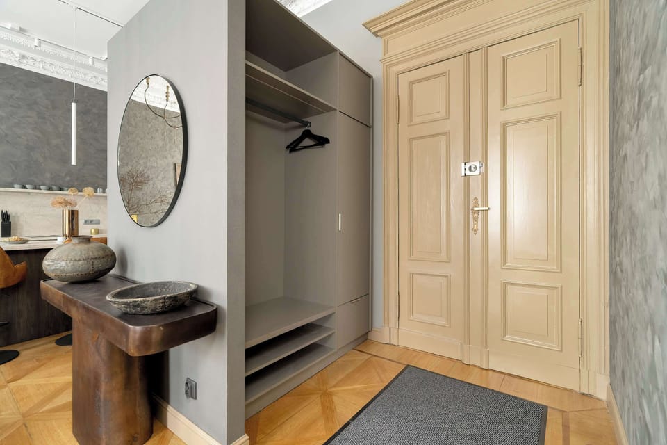 A close-up of a hallway with a round mirror, a side table, and a cozy ambiance.