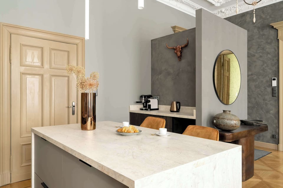 A different angle of the kitchen, showcasing a marble backsplash, cabinets, and decorative vases.