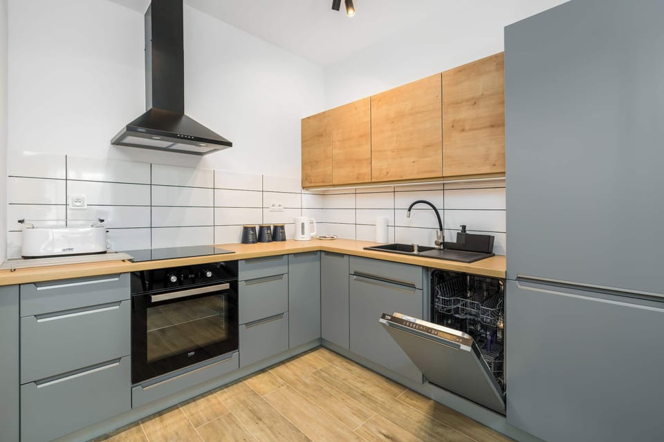  A slightly different angle of the kitchen, emphasizing the modern appliances and tiled backsplash.
