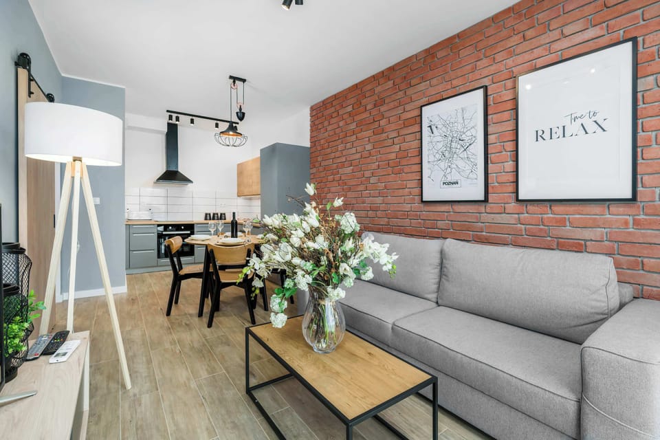 Another perspective of the living room, showing the brick wall decor and stylish lighting fixtures.