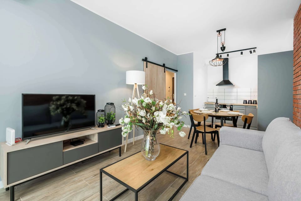 Living area with a TV mounted on a gray wall, a small coffee table, and contemporary furniture, designed for relaxation.