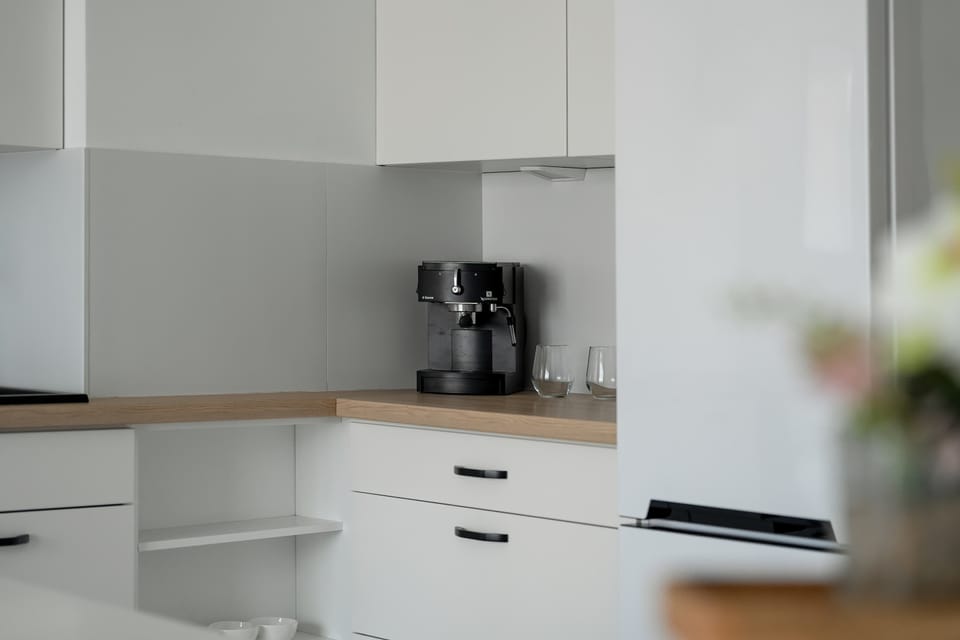 The coffee machine set on a wooden countertop adds functionality to the kitchen and invites aromatic mornings.