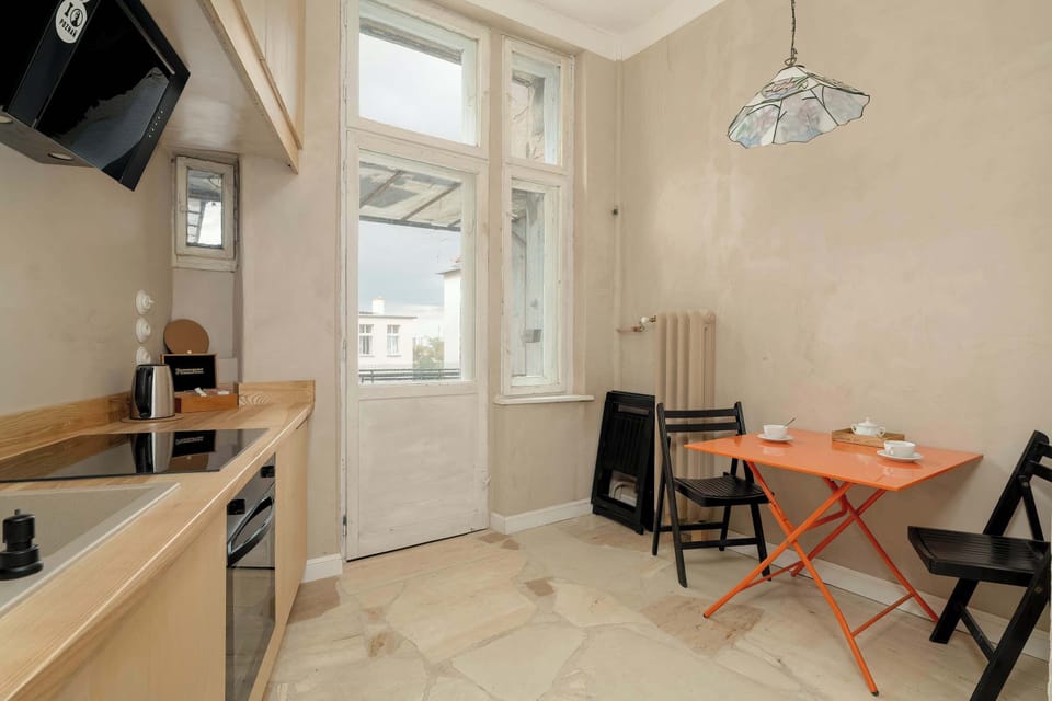 The kitchen is designed for both function and comfort, featuring a table for two and access to a balcony for a pleasant dining experience.