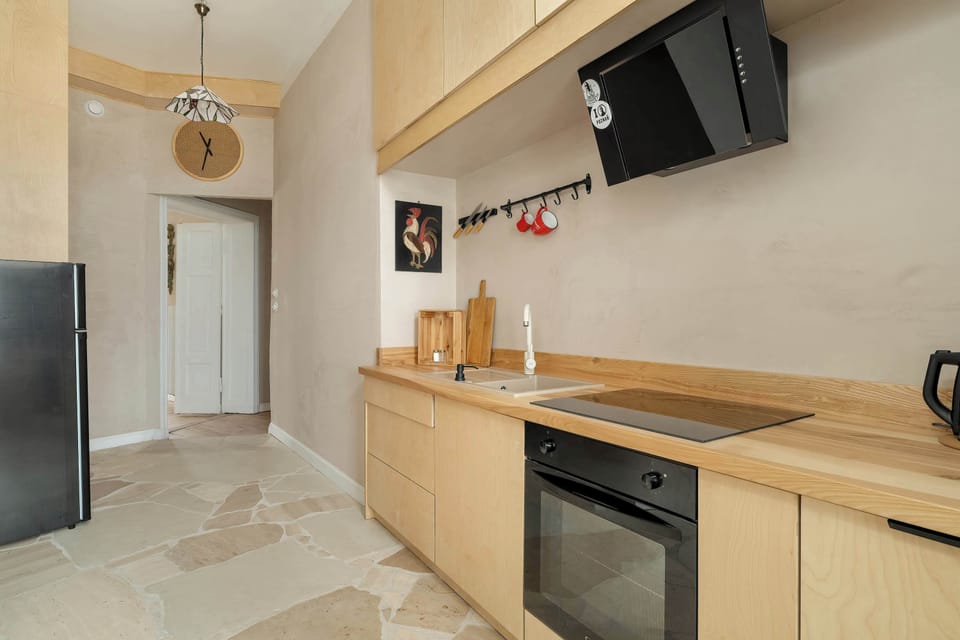 The kitchen is fully equipped with modern appliances, including an oven, electric hob, and a refrigerator with a freezer, ensuring convenience for meal preparation.