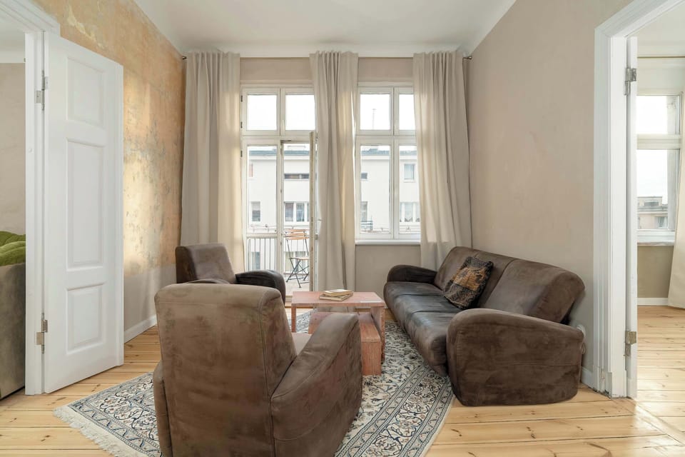 This comfortable bedroom is furnished with a fold-out sofa and two armchairs, offering ample seating for relaxation or socializing.