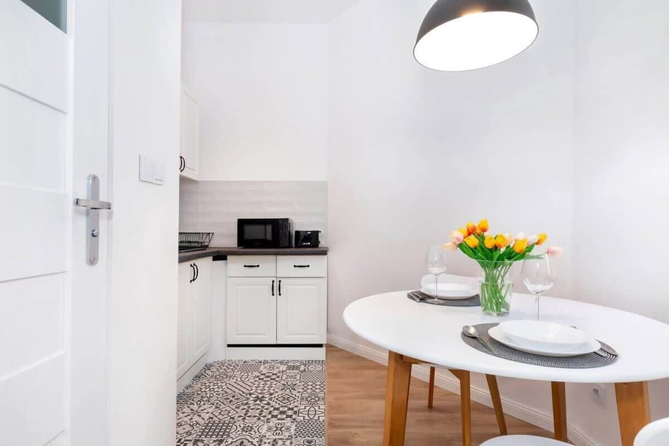 Bright and functional kitchen area with a fridge, a freezer, a microwave, a stove, a kettle, and a toaster.