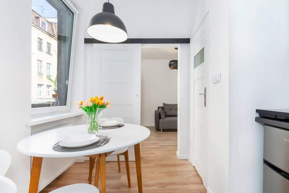 Independent kitchen in the studio with stylish dining area, a microwave, a fridge, a stove, a toaster and a kettle.