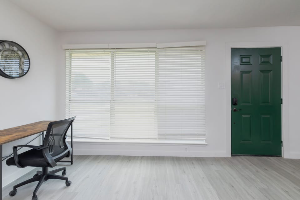 Dedicated workspace with ergonomic chair and wooden desk off of the living room.