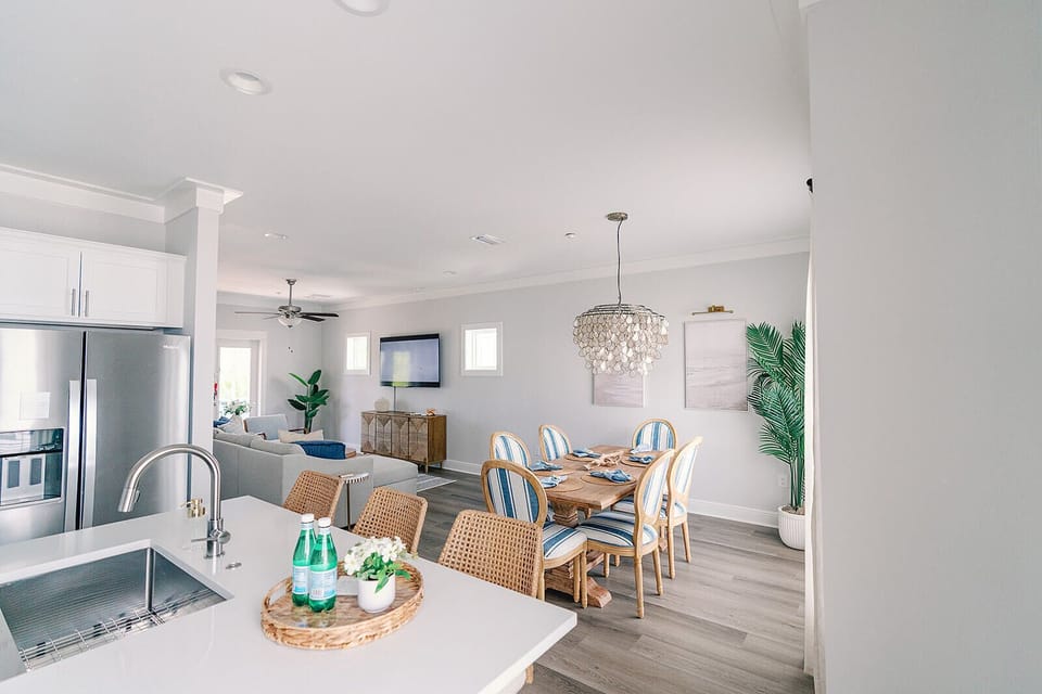 Enjoy an open-concept living and dining area filled with natural light, stylish coastal decor, and plenty of space for relaxing and entertaining during your stay.