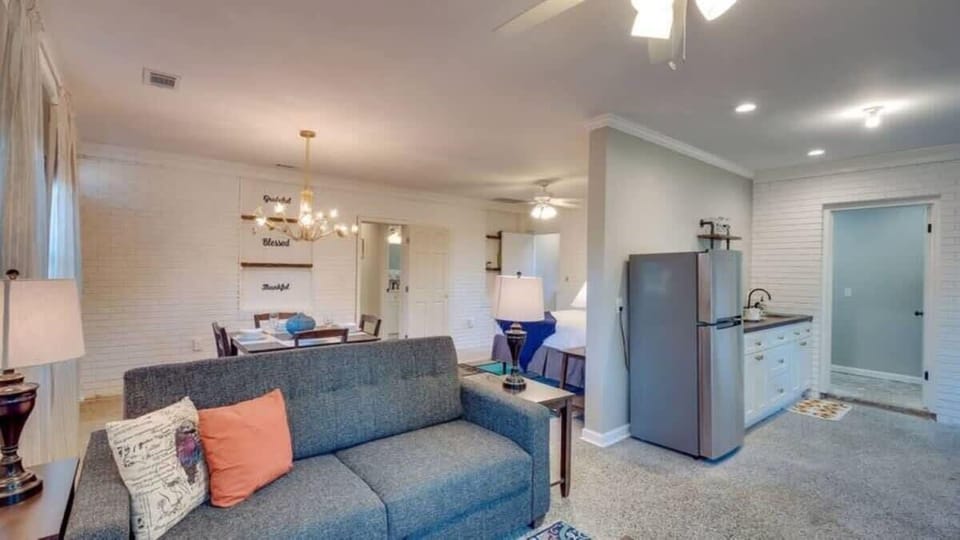 The living room offers comfortable seating and opens to the dining and kitchen areas.