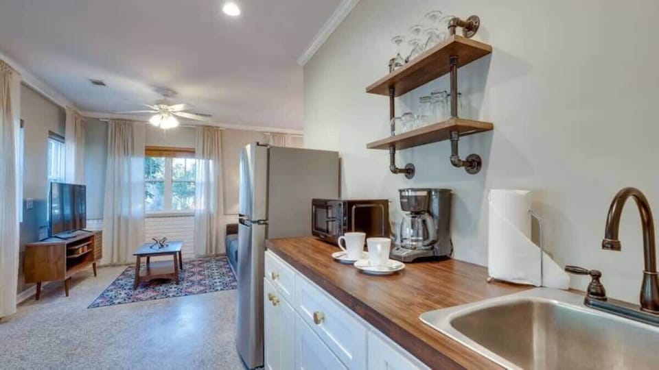 The compact kitchenette is well-equipped with a refrigerator, microwave, and essentials.