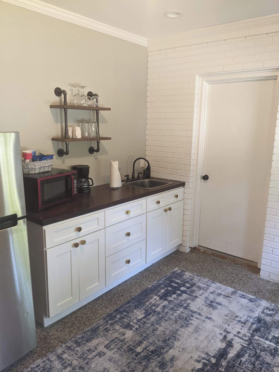 The kitchenette includes ample storage, counter space, and a cozy setup.